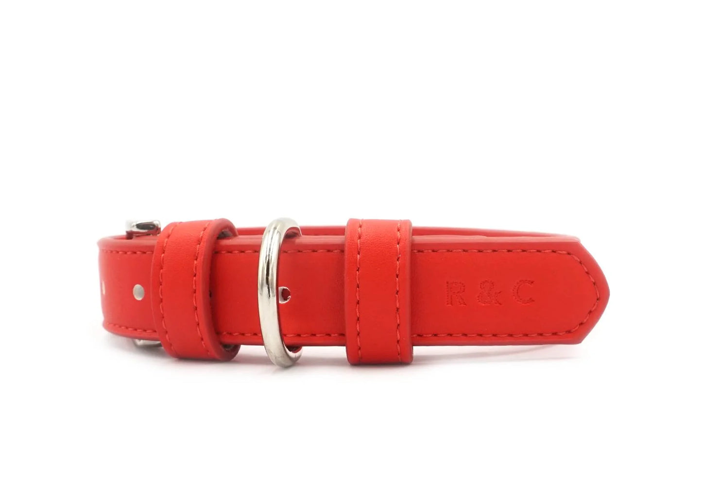 Red leather dog collar with a silver ring on a white background