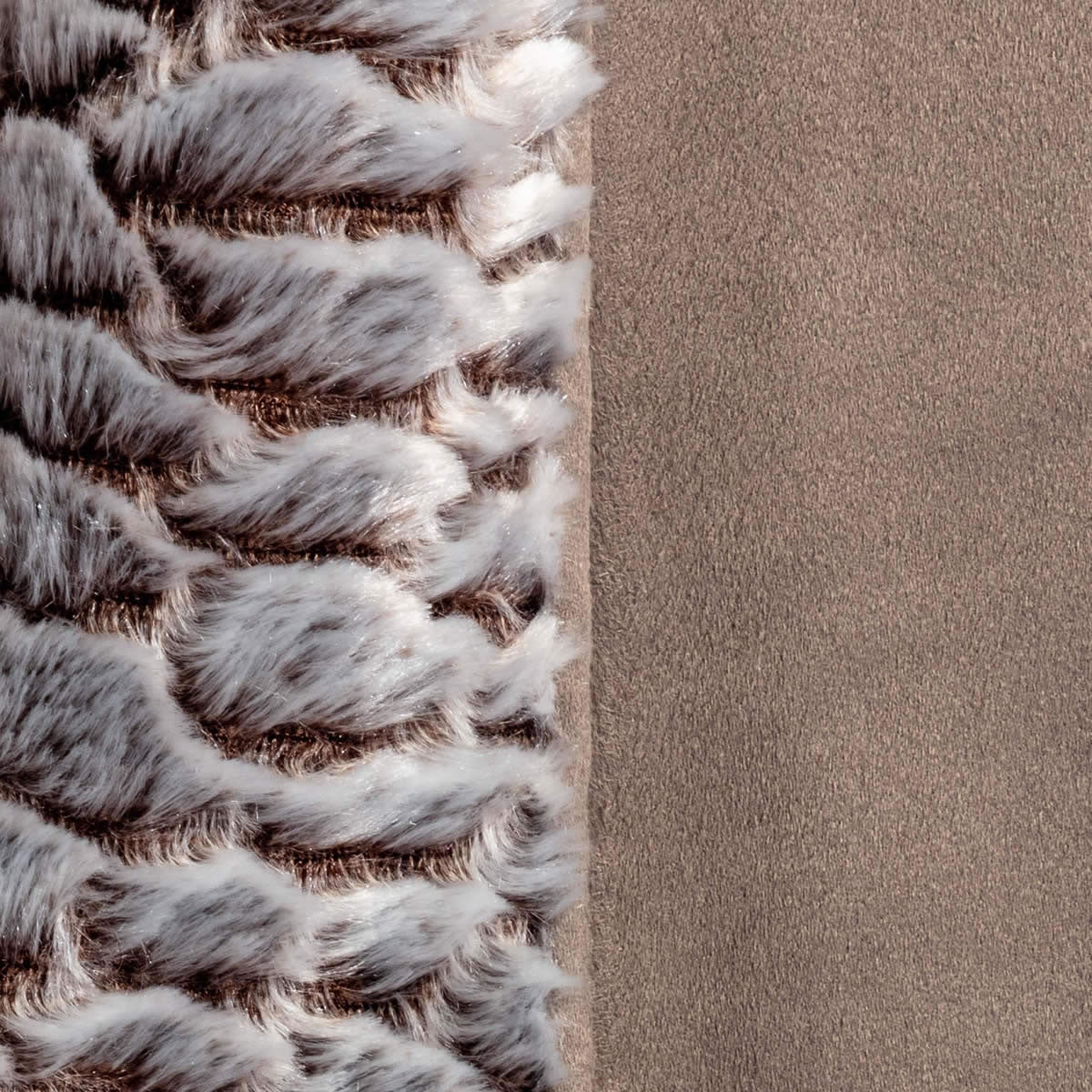 Close-up of a textured rug corner with a neutral color palette.