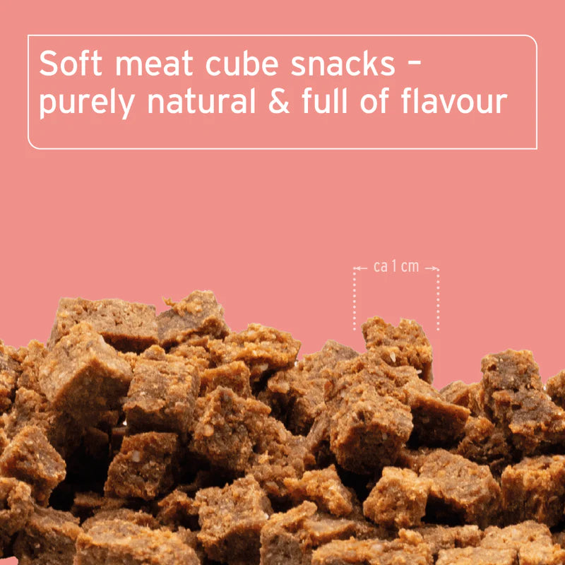Soft meat cube snacks on a pink background with text about their natural and flavorful qualities.