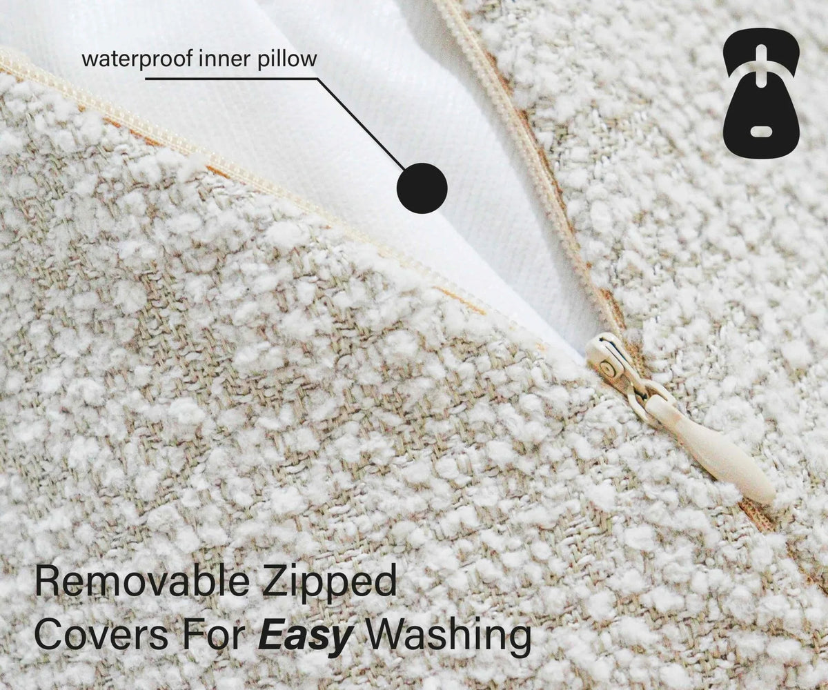 Close-up of a textured pillow with a zipper and text indicating waterproof inner pillow and removable zipped covers for easy washing.