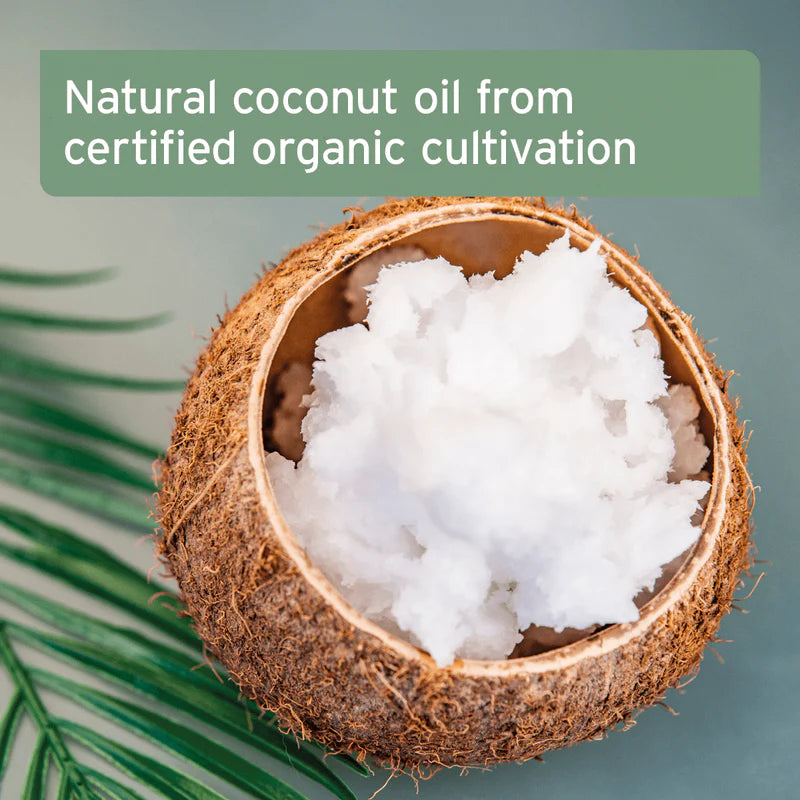 Coconut oil in a split coconut with text 'Natural coconut oil from certified organic cultivation' on a green background.