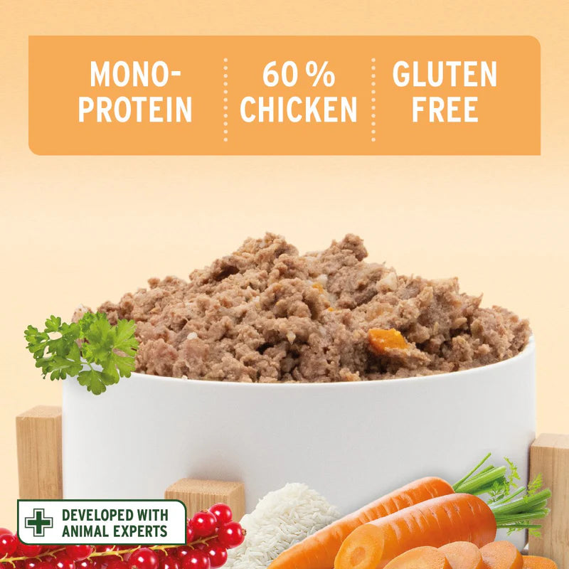 Bowl of ground meat with ingredients and text indicating mono-protein, 60% chicken, and gluten-free on a beige background.