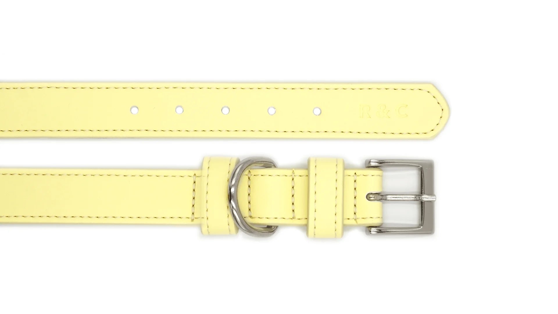 A pale yellow leather collar strap with silver-tone metal hardware, including a buckle, loop, and adjustment holes, shown on a plain white background.